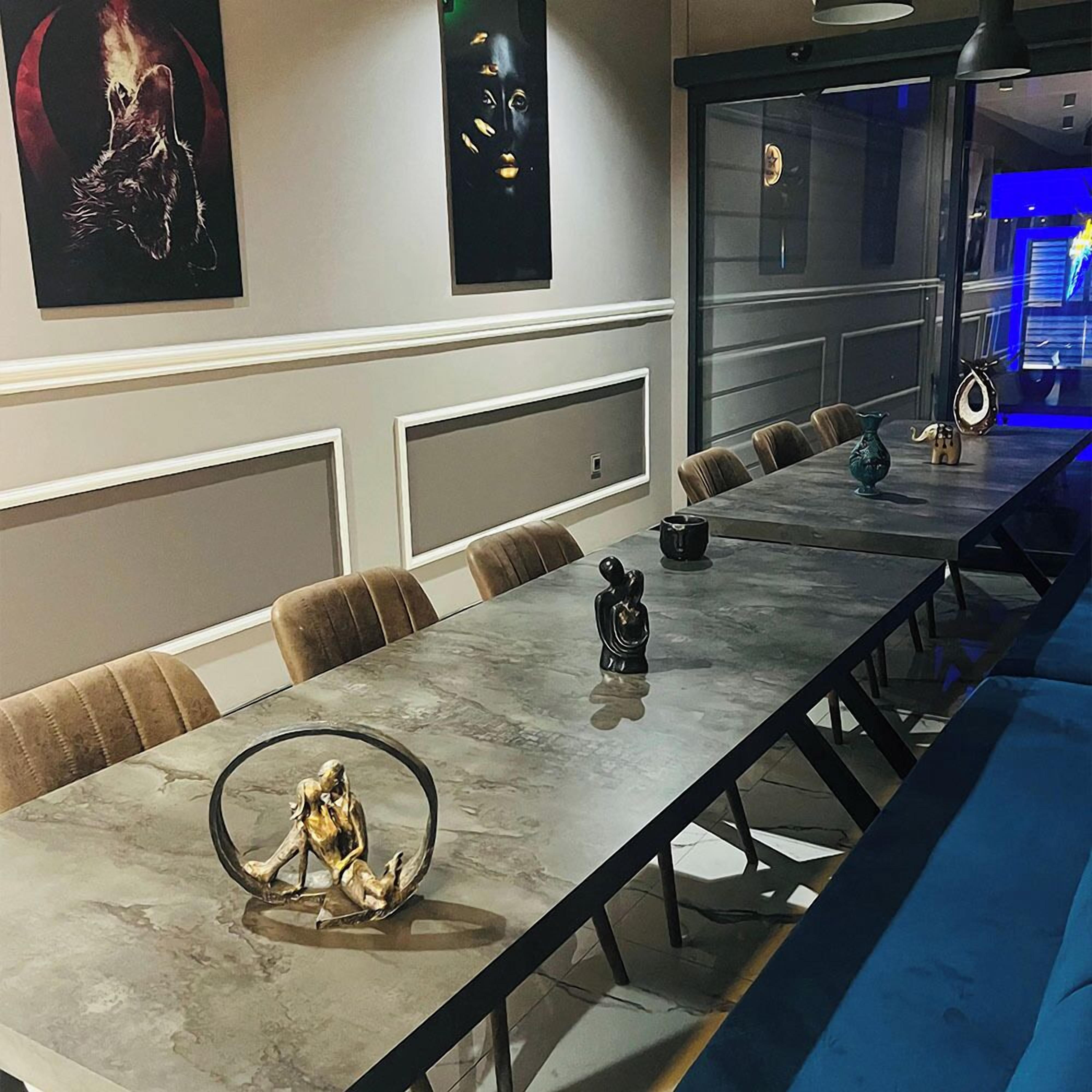 A modern conference room with a long table, comfortable chairs, and decorative items.