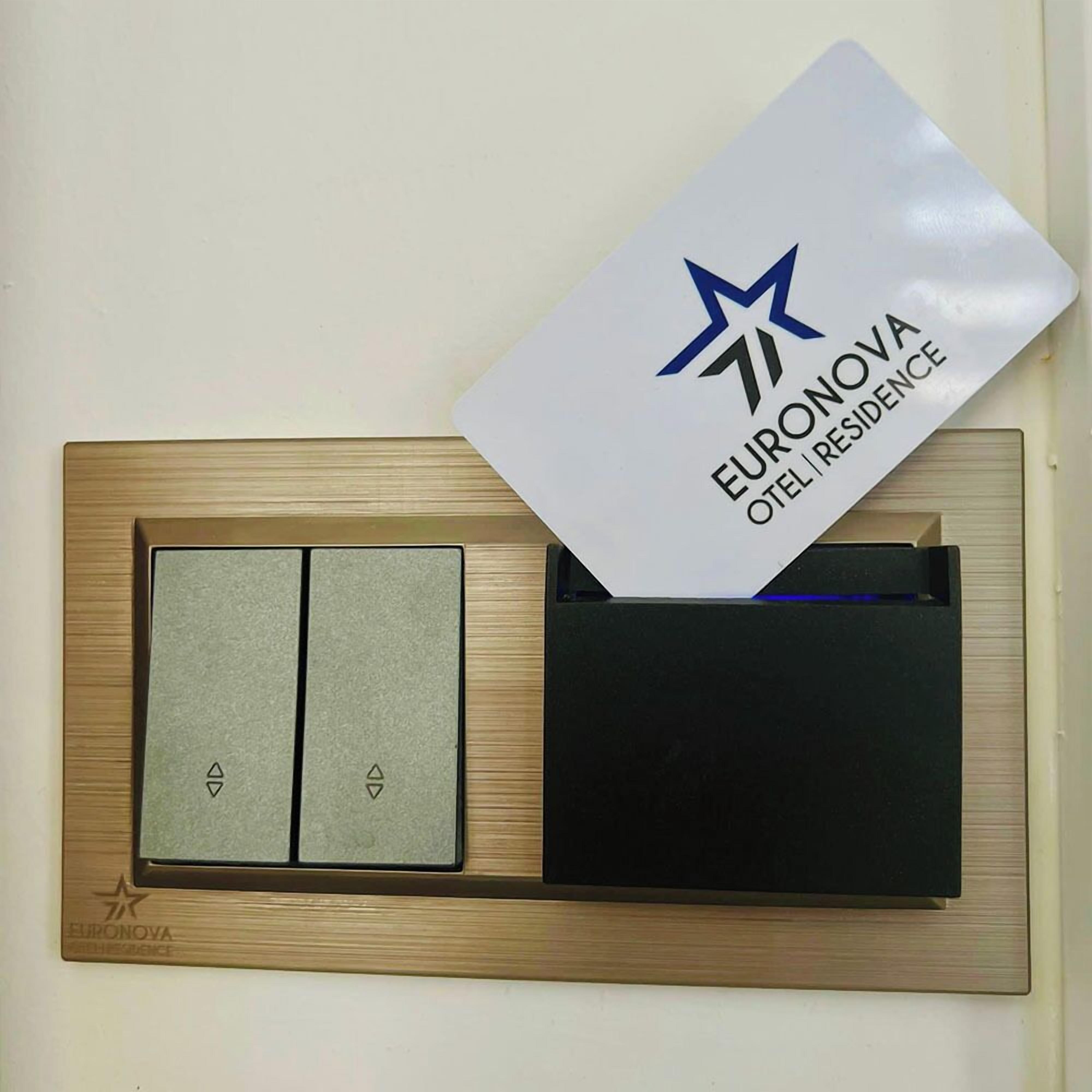 A hotel room's control panel with a keycard slot and a small display.