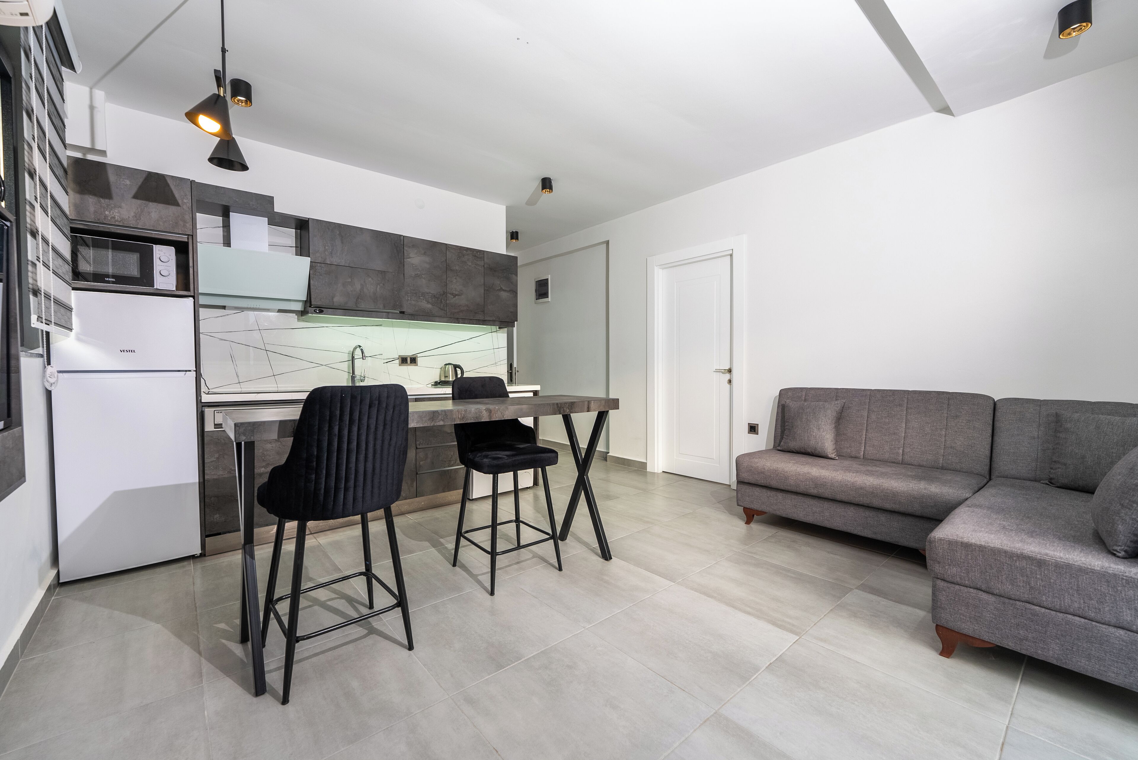Una cocina moderna con comedor, sofá y refrigerador.