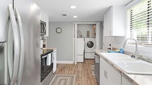 A modern kitchen with stainless steel appliances, a built-in oven, and a large sink. - The Horseman's Retreat (Ocala)