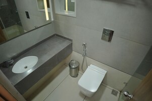 A modern bathroom with a sink, toilet, and shower.