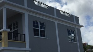 A multi-story building with balconies and large windows.