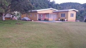 A two-story house with a covered porch and a small garden area. - Mckay's Home Away from Home (Hatfield)