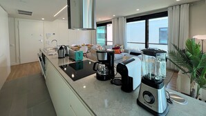 A modern kitchen with a built-in island, a coffee maker, a blender, and a toaster. - FARO DESIGN 1 by HOMING (Faro)