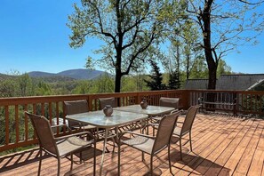 A wooden deck with a table and chairs, overlooking a mountainous landscape. - Torry Ridge--hot tub, mountain views, fireplace (Lyndhurst)