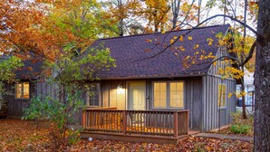 A cabin with a wooden deck, a front porch, and a covered porch area. - White Rock Cabin--1BR, ADA, kitchenette, fireplace (Lyndhurst)