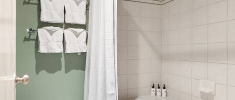 A bathroom with a bathtub, a shower curtain, and towels hanging on a rack.