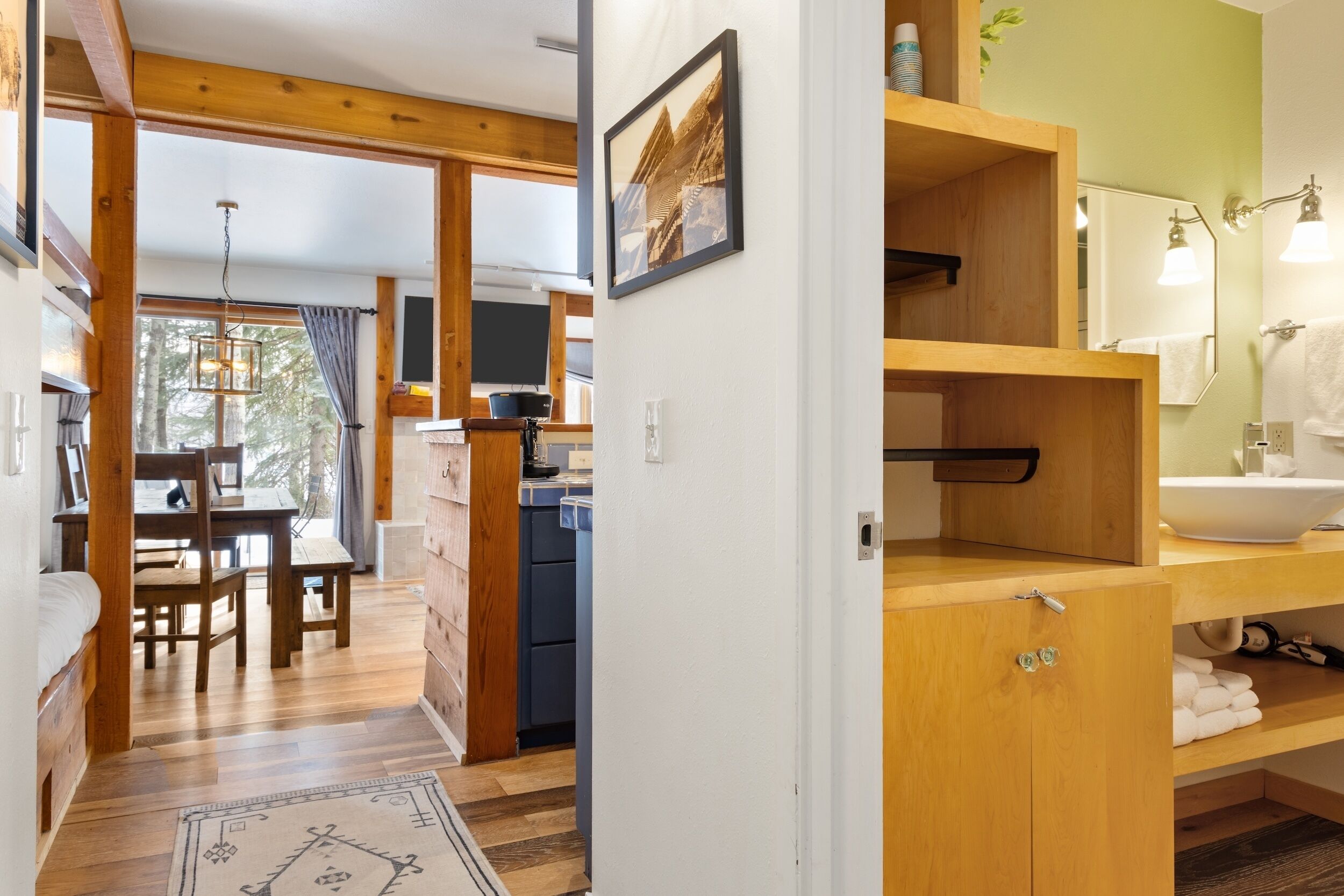 A wooden interior with a dining area, kitchen, and bathroom.