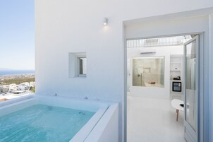 A modern bathroom with a bathtub, shower, and glass doors.