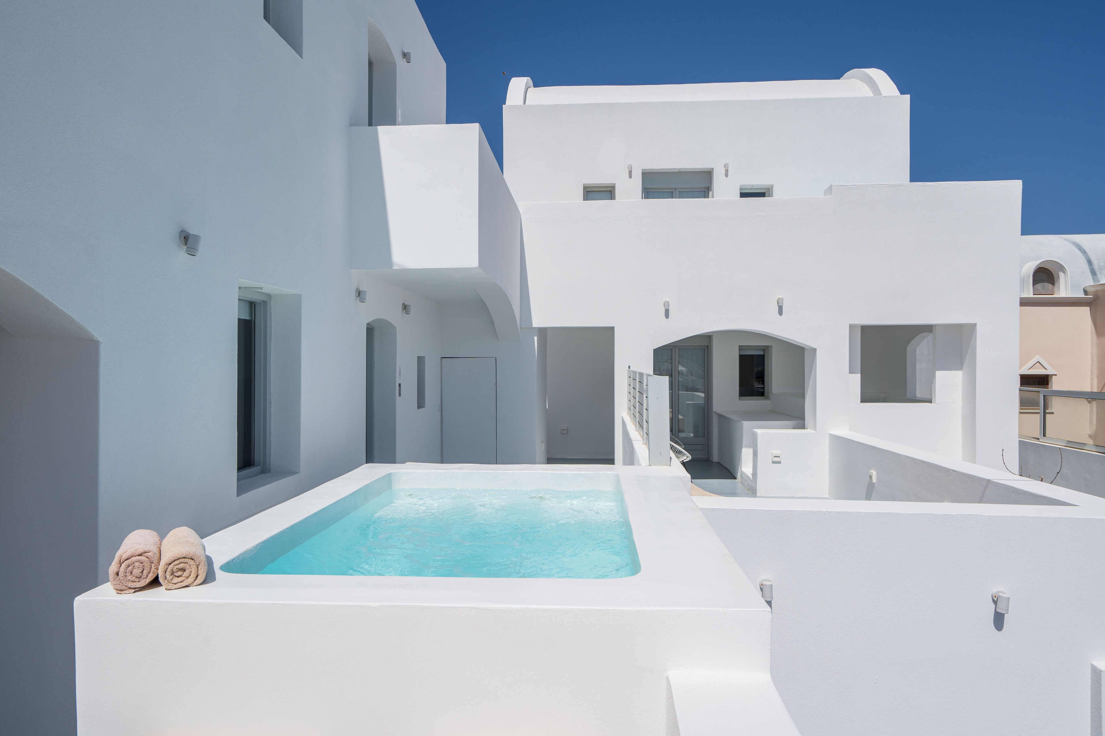 Un edificio moderno blanco con piscina y zona cubierta.