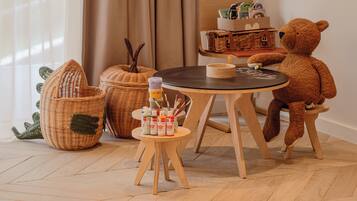 Una habitación acogedora con una mesa de madera, un osito de peluche y cestas de mimbre.