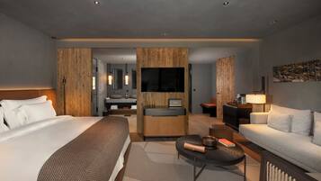 A modern hotel room with a large bed, a sitting area with a sofa and coffee table, a wooden accent wall, a TV, and a bathroom with a sink and mirror.