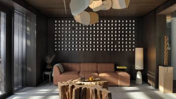 A modern living room with a wooden ceiling, a patterned wall, a sofa, a coffee table, and a lamp.