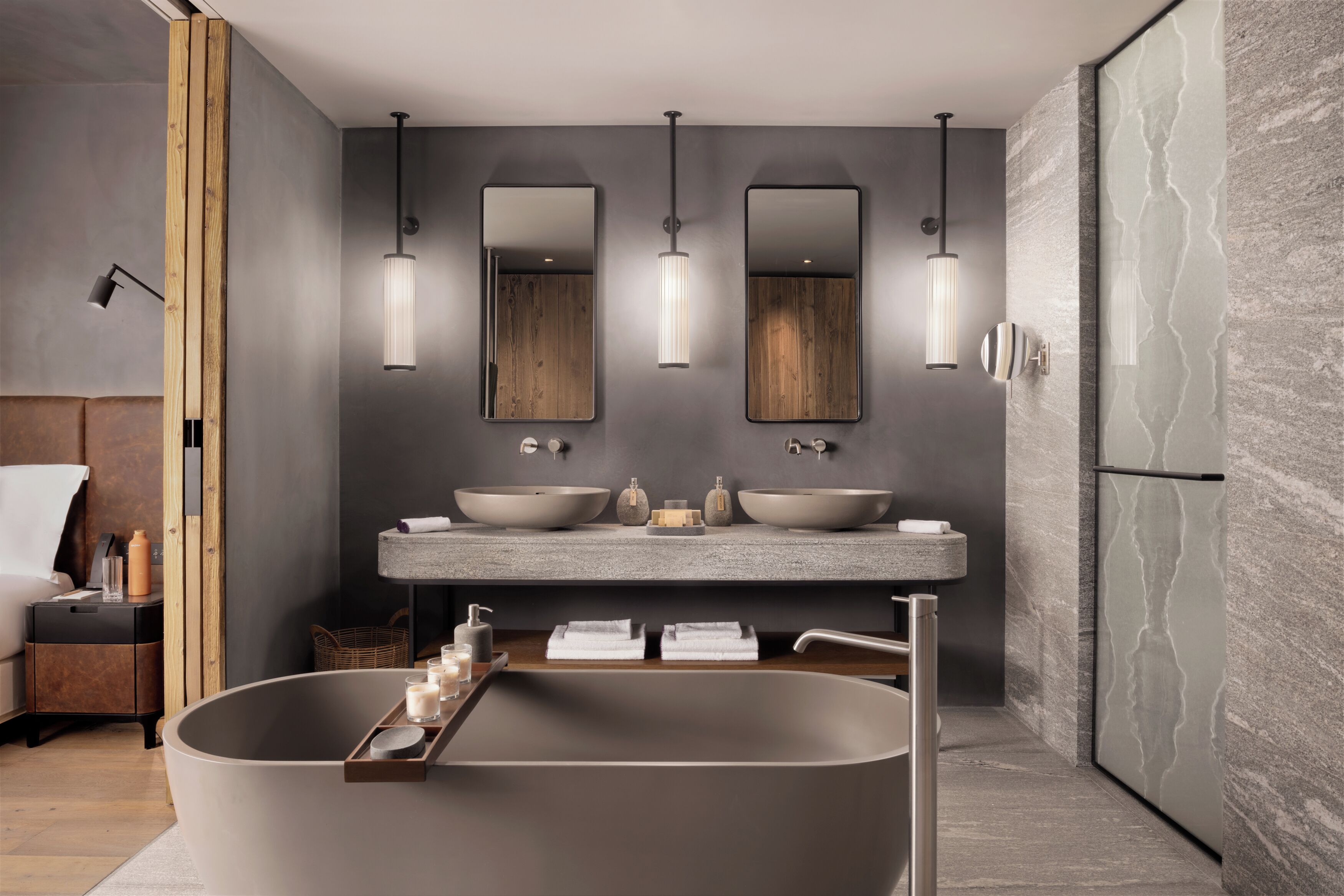 A modern bathroom with a freestanding bathtub, two large mirrors, and a vanity with a large sink.