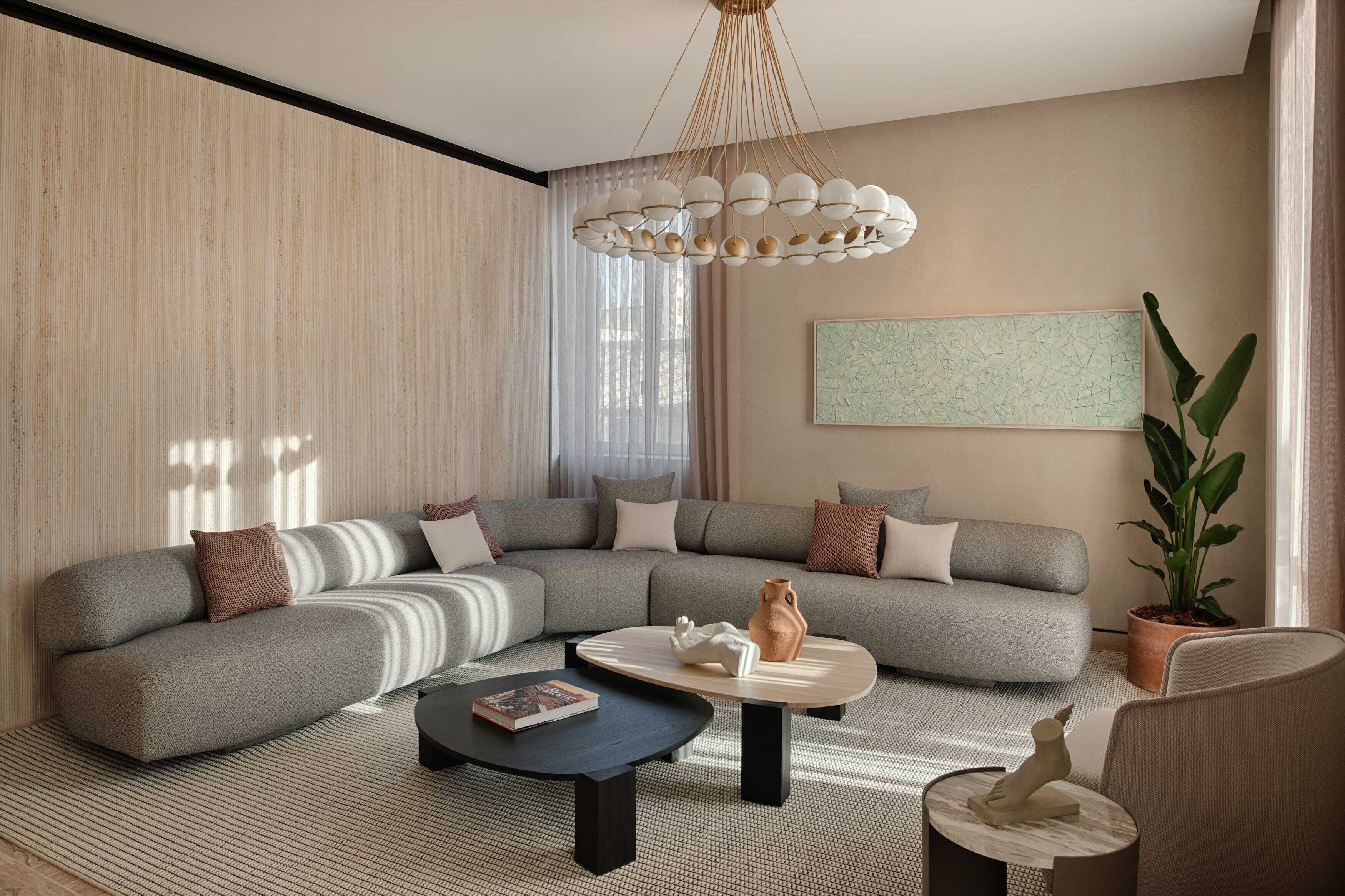 A modern living room with a sectional sofa, a round coffee table, and a hanging light fixture.