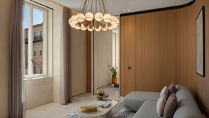 A modern living room with a sofa, a coffee table, and a pendant light. - Six Senses Rome (Rome)