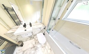Ein Badezimmer mit Badewanne, Dusche und Toilette.