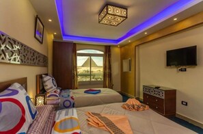 Enjoy a comfortable stay with two beds, a flat-screen TV, and a large window offering a view of a nearby pyramid.