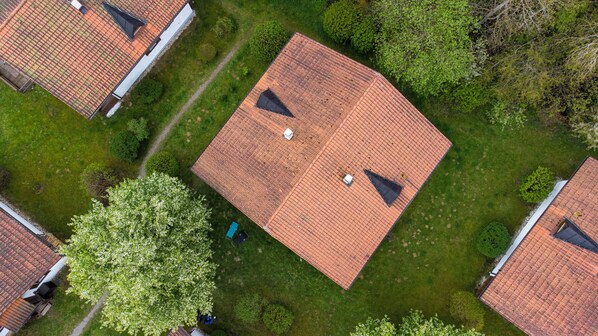 An aerial view of a residential area with multiple houses featuring red-tiled roofs and small front yards.