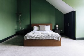 A bedroom with a bed, a nightstand, a lamp, and a wardrobe. - Emerald 2BD Retreat in Historic Building, New Town (Edinburgh)