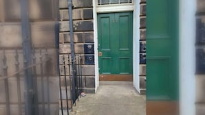 A green door with the number 33, a metal gate, and a concrete floor. - Emerald 2BD Retreat in Historic Building, New Town (Edinburgh)