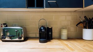 A kitchen counter with a toaster, a coffee maker, and a coffee container. - Emerald 2BD Retreat in Historic Building, New Town (Edinburgh)