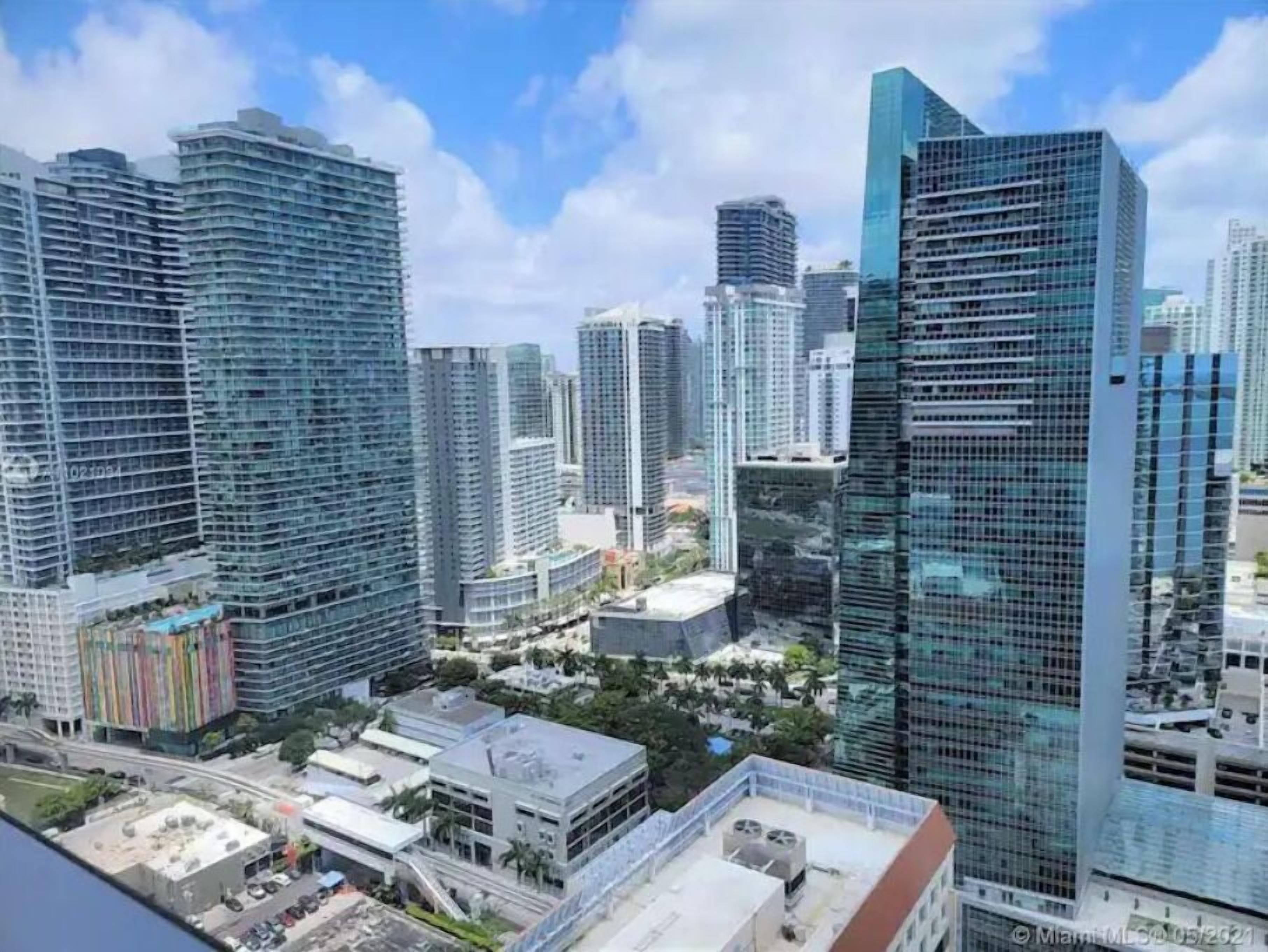 A high-rise urban area with modern skyscrapers, a mix of residential and commercial buildings, and a clear sky.