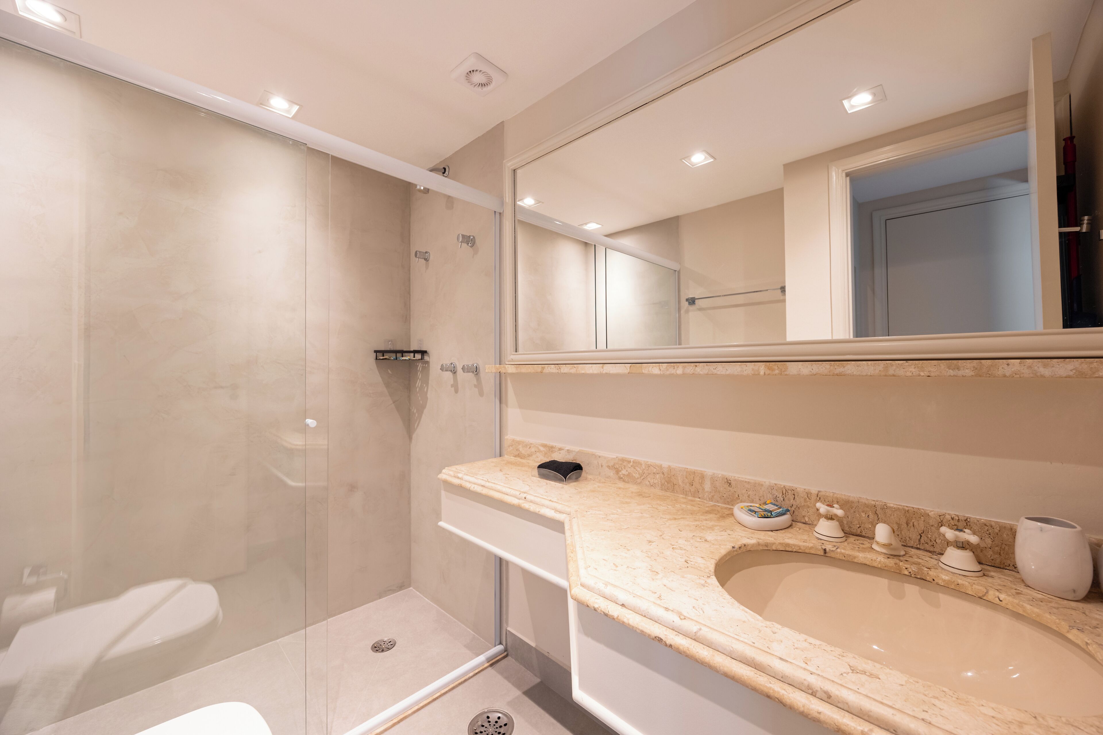 A modern bathroom with a walk-in shower, a toilet, and a sink with a vanity.
