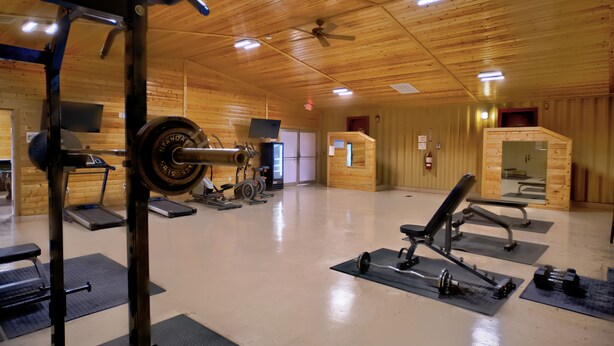 A gym with weightlifting equipment, treadmills, and exercise mats. - Ellipse Global Lodge (Carlsbad)