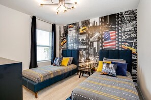 Een hotelkamer met twee bedden, een groot raam en een muur versierd met stadsbeelden in filmstrookstijl.