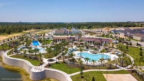 Residents enjoy a central pool surrounded by manicured lawns and palm trees.