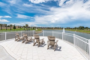 Relax in a serene outdoor seating area overlooking a tranquil body of water.