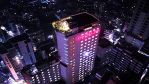 A high-rise hotel with multiple floors, a rooftop garden, and illuminated signage. - Central Inn (Dhaka)