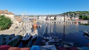 Un puerto con barcos, un edificio blanco grande e iglesia con campanario.
