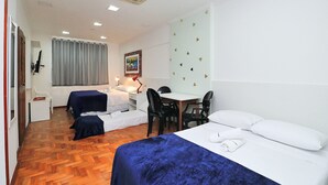 A hotel room with a bed, two single beds, a desk, and a chair. - Rio Spot C058 (Rio de Janeiro)