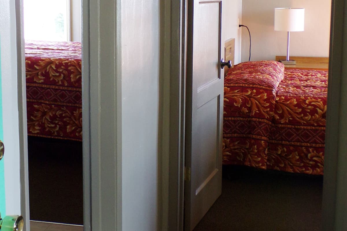 A hotel room with a bed, a nightstand, a lamp, and a ceiling fan.