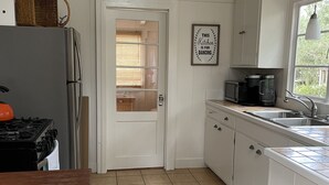 A kitchen with white cabinets, a refrigerator, a stove, a microwave, and a sink. - Cozy get-away in Pacific Grove (Pet Friendly!) (Pacific Grove)