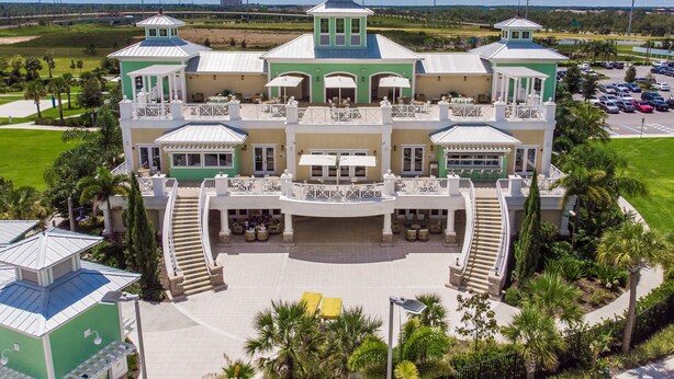 A large, multi-story building with a central courtyard, multiple balconies, and a clock tower. - 8 Bdrm Villa w/Pool, Theater Near Disney w/ Waterpark & Free Shuttle Service (Kissimmee)