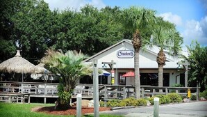A restaurant with a sign reading "Cracker's" surrounded by palm trees and a thatched-roof structure. - Crystal River Getaway , Free Kayaks + Minutes to Three Sisters Springs. Pet ok  (Crystal River)