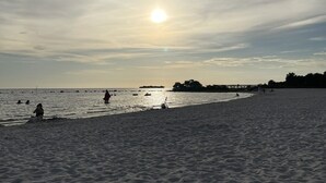 A beach with people and boats, a clear sky, and a sun setting or rising. - Crystal River Getaway , Free Kayaks + Minutes to Three Sisters Springs. Pet ok  (Crystal River)