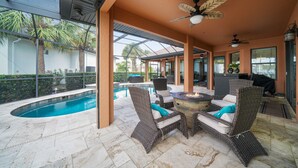 An outdoor patio with a pool, wicker furniture, and ceiling fans. - Beautiful Gulf Access home Amazing pool sunsets  (Punta Gorda)