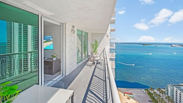 A balcony with a view of the ocean and a distant island. - The Club 3305 DUPLICATE · High Floor Ocean View Unit In Brickell - Parking (Miami)