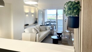 Een moderne woonkamer met een bank, een eettafel en een balkon met uitzicht.