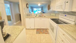 A kitchen with white cabinets, a microwave, an oven, and a dishwasher.
