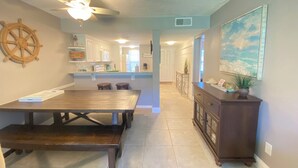 A spacious kitchen with a dining area, a ceiling fan, and a view of the living room.