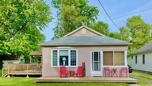 A small, single-story house with a porch, a deck, and a small garden area. - Bay Beach Cottage in Crystal Beach....perfect for a quiet getaway.  (Crystal Beach)