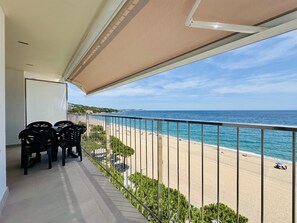 A balcony with a view of the beach and ocean.