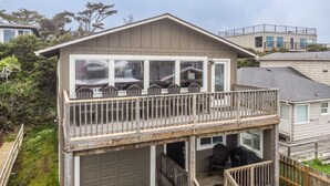 A two-story house with a balcony, a garage, and a deck.