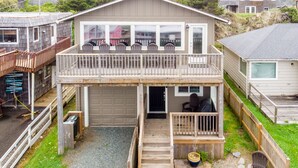 A two-story house with a balcony, a garage, and a small porch area.