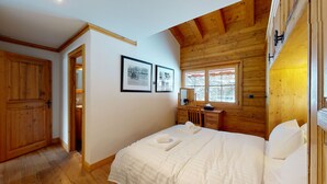 A cozy bedroom with a wooden ceiling, a bed with white linens, a wooden dresser, and two framed pictures on the wall. - Terrasses du Paradis 7A LUXE & CENTER apart 7 pers (Haute-Nendaz)